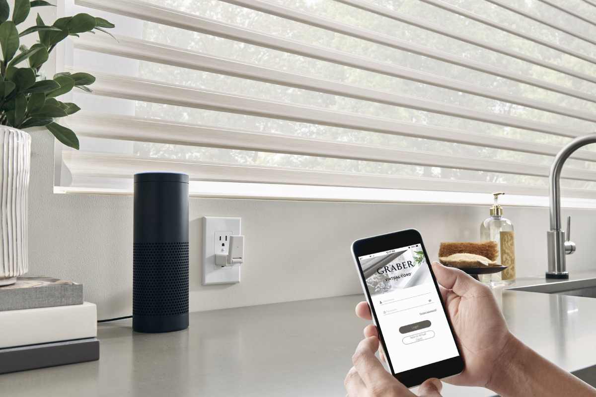 hand-holding-smartphone-using-graber-mobile-app-1200px Hand holding smartphone using Graber® mobile app in a kitchen with motorized blinds near Silver Springs, MD